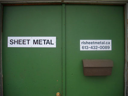 Photo of the shop door with contact information
